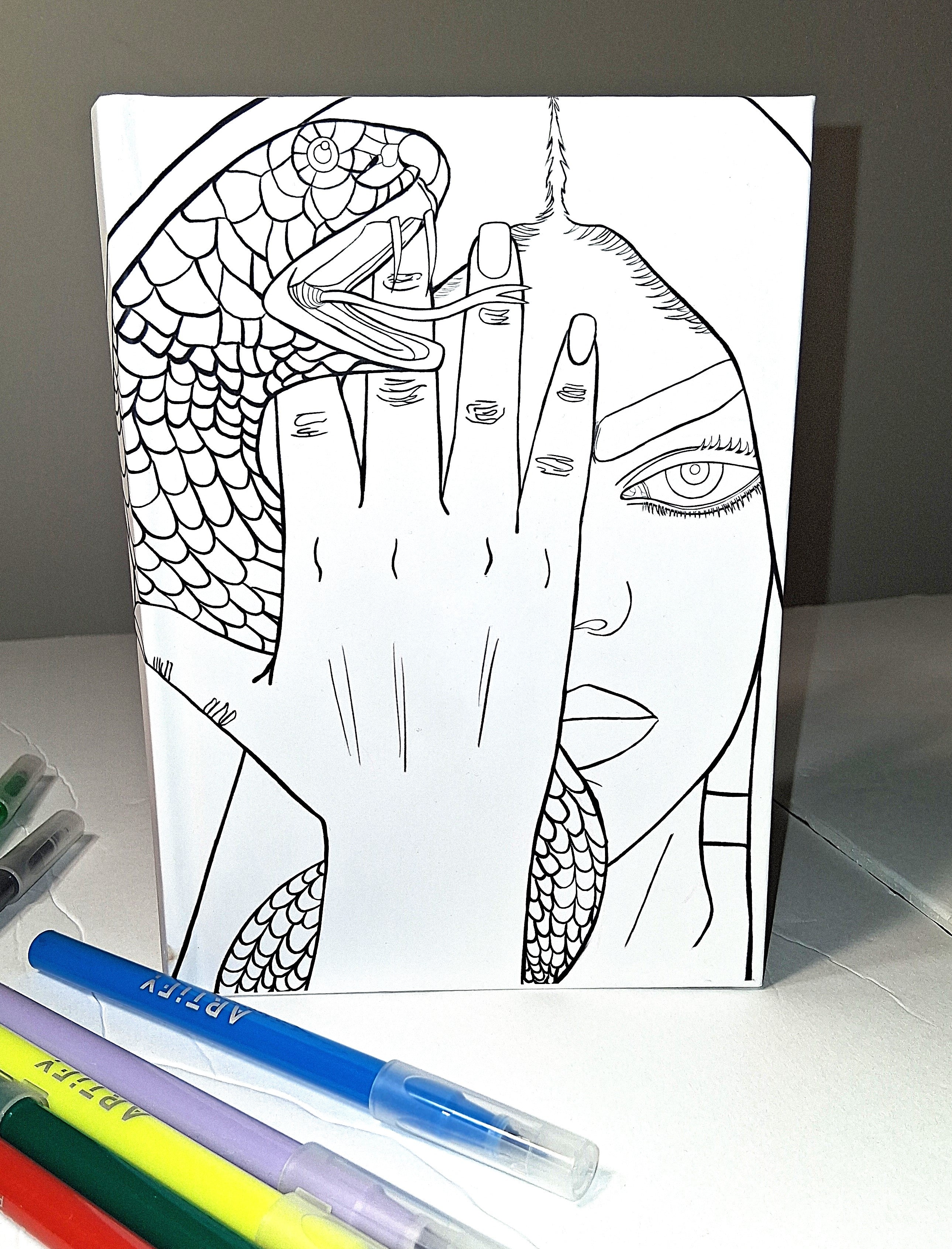 Coloring book with a snake and hand design on a white surface with coloring pens.