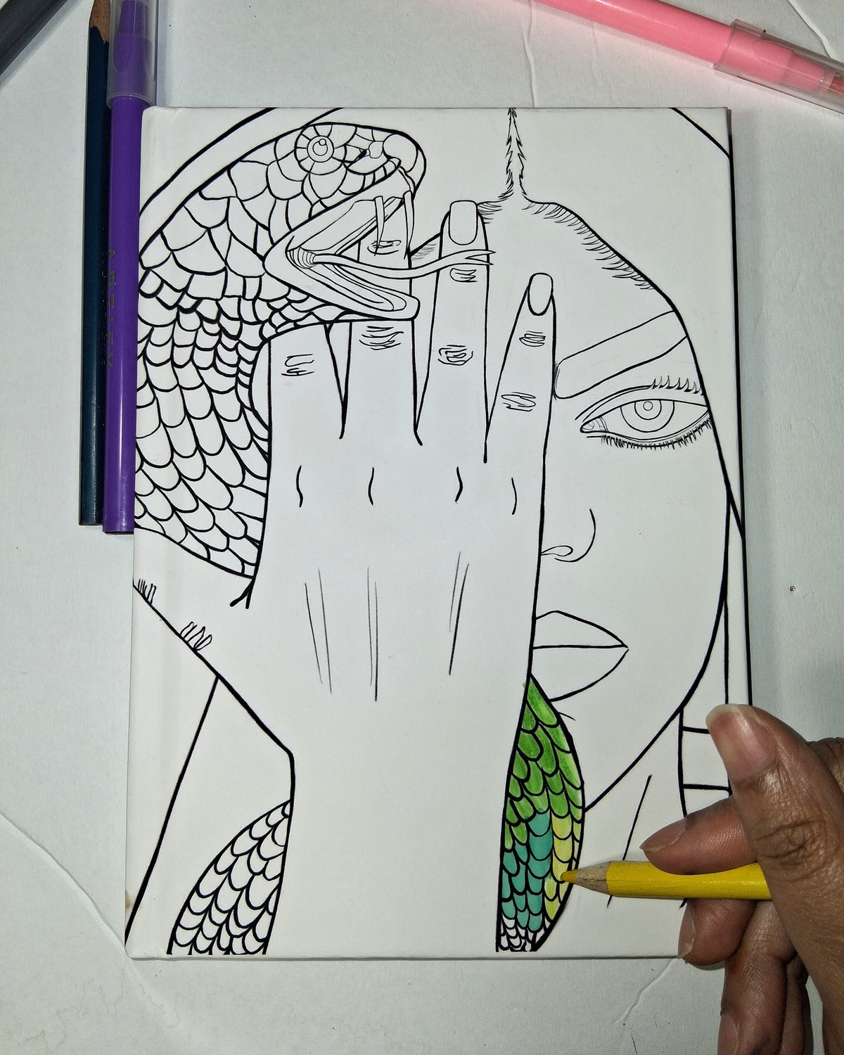 Coloring book page with abstract design of a hand and snake, partially colored with a green leaf.